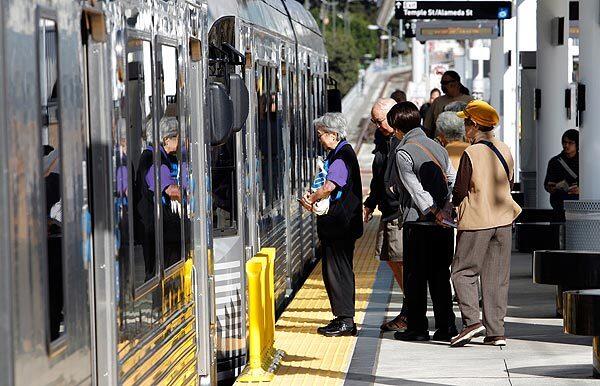 Passengers board the eastbound Gold Line train at the Little Tokyo Station on the first day of normal operation for the new rail extension to and from East L.A.