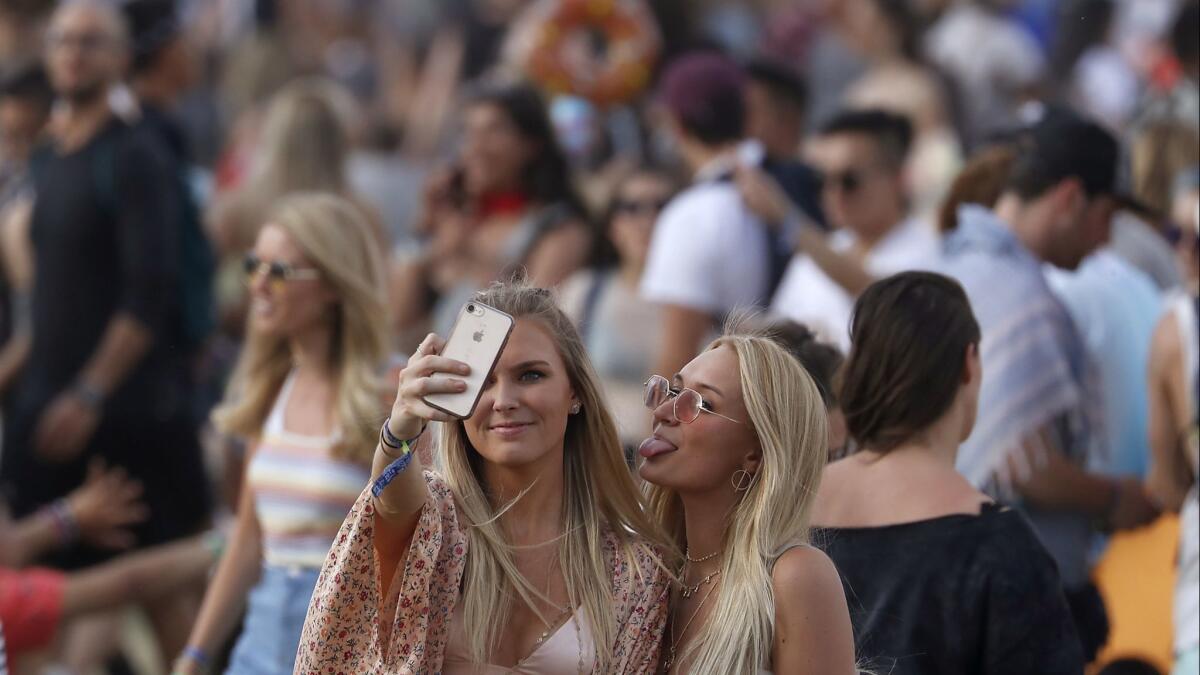 Coachella-goers make time to take a selfie on the crowded grounds of the festival in 2018.