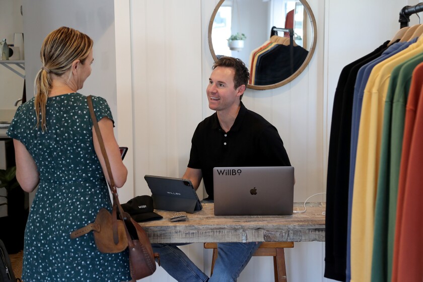 Founder Robbie McInerny speaks to a customer visiting from Ventura after she purchased a black hat.