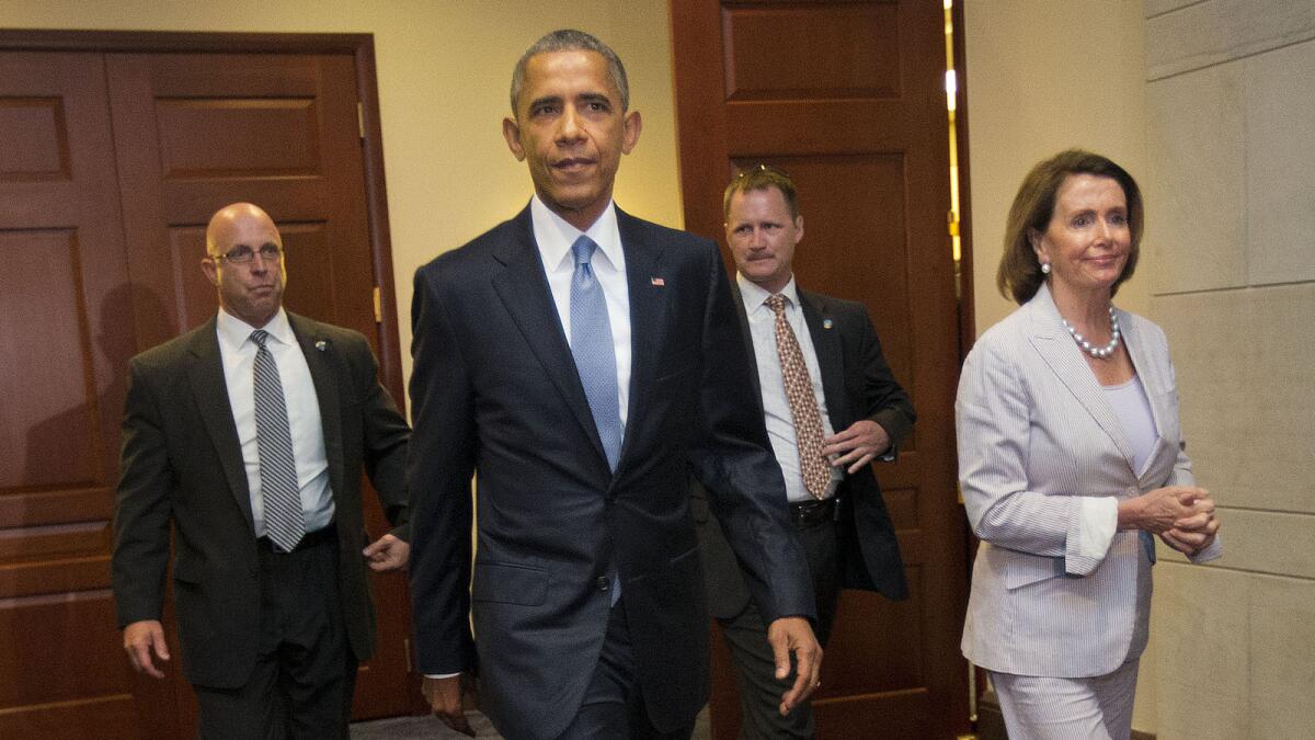 President Barack Obama walks with House Minority Leader Nancy Pelosi of Calif., after meeting with House Democrats on Capitol Hill in Washington.