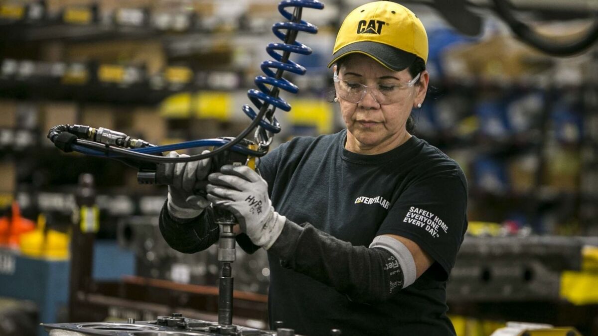 Margarita Cardenas attaches an engine head at a Caterpillar manufacturing plant in Seguin, Texas. The company said this week that tariffs had cost it about $40 million in the third quarter.
