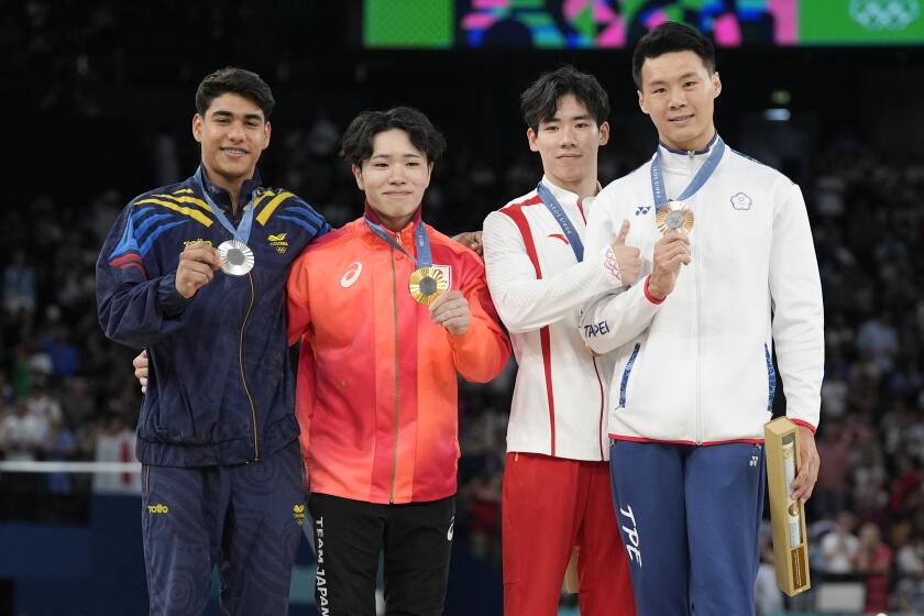 Silver medalist Angel Barajas, left, of Colombia, celebrates with gold medalist Shinnosuke Oka.