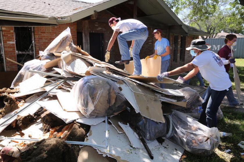 Students clean debris at a home in West, Texas, that was damaged in the fertilizer plant explosion that killed 14 people last month. Lawyers said Saturday the plant only had $1 million in liability coverage.