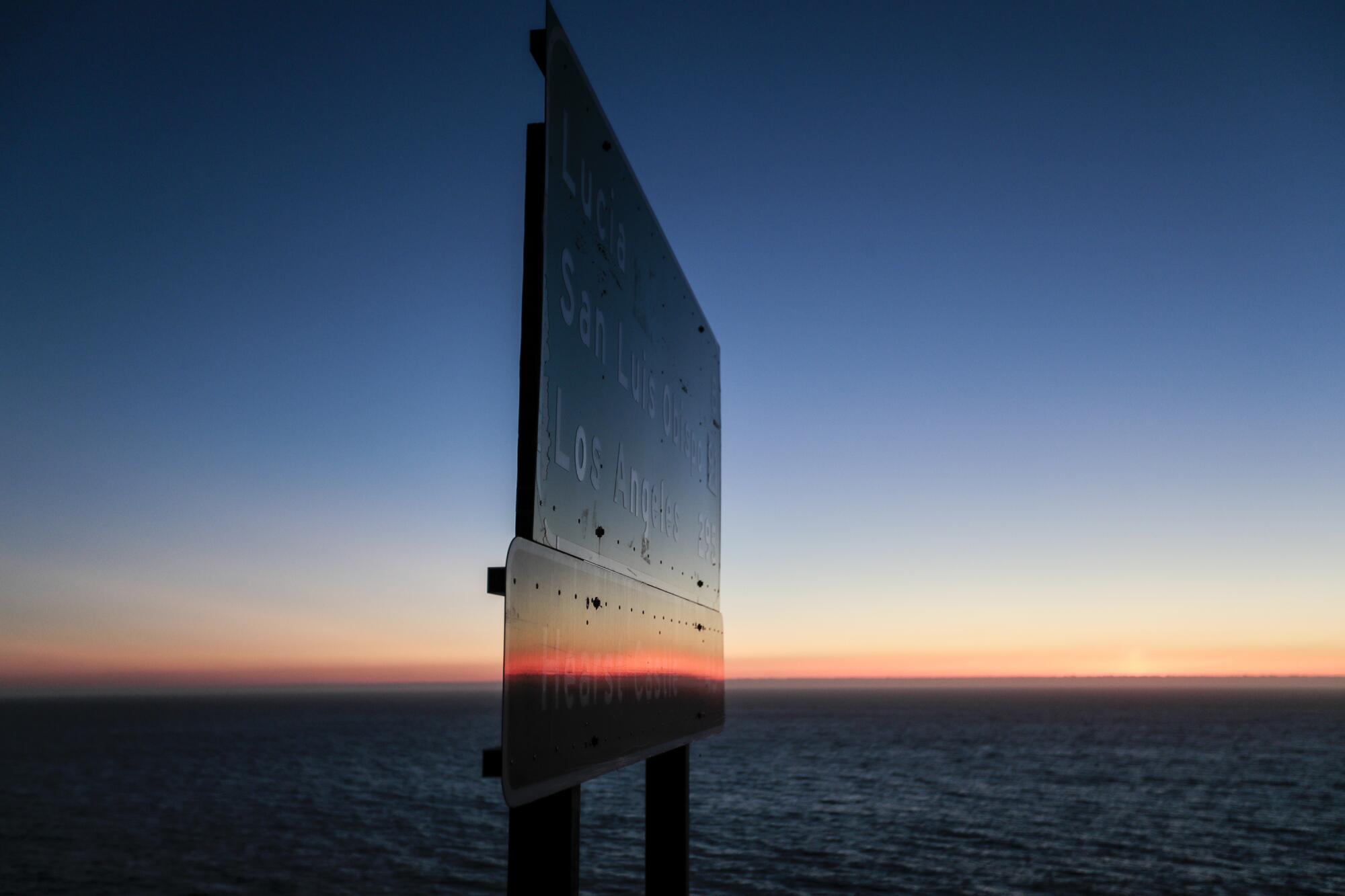 A road sign by the ocean.