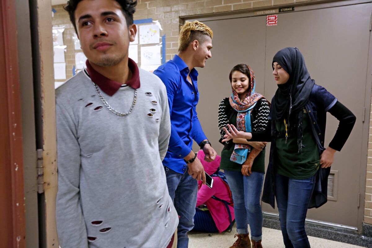 William Villeda, 17, left, of El Salvador, Farhad Hamidi, 18, Henna Sadiq, 16, and Maryam Durrani, 16, all of Afghanistan, during lunch at Margaret Long Wisdom High School in southwest Houston.