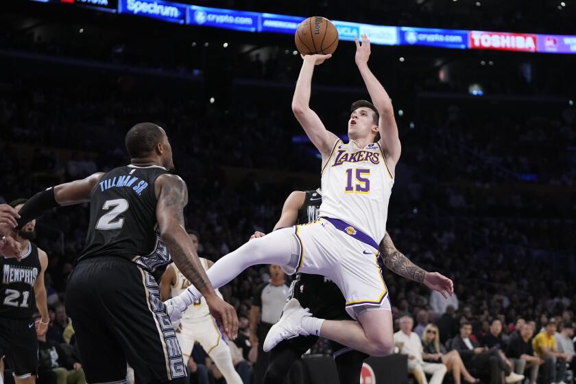 Los Angeles Lakers guard Austin Reaves, right, shoots as Memphis Grizzlies forward Xavier Tillman defends during the first half in Game 3 of a first-round NBA basketball playoff series Saturday, April 22, 2023, in Los Angeles. (AP Photo/Mark J. Terrill)