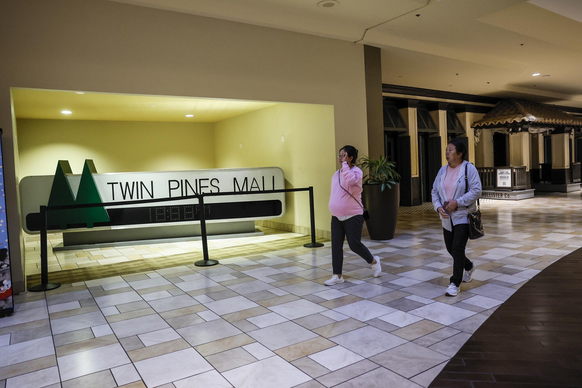Shoppers at the Puente Hills Mall stroll past a prop from the movie "Back to the Future," which was filmed here.