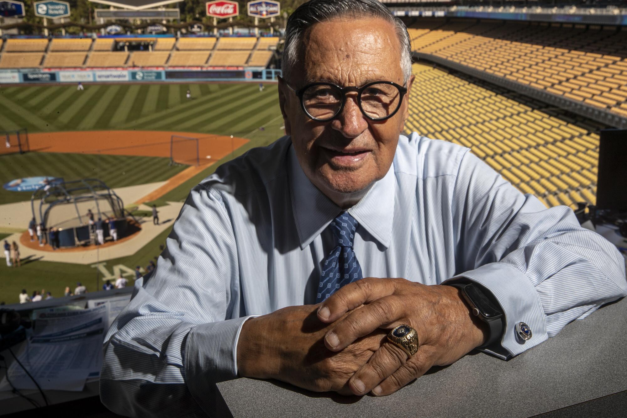 Veteran Dodgers broadcaster Jaime Jarrin sits in the Dodger Stadium booth with the field behind him.