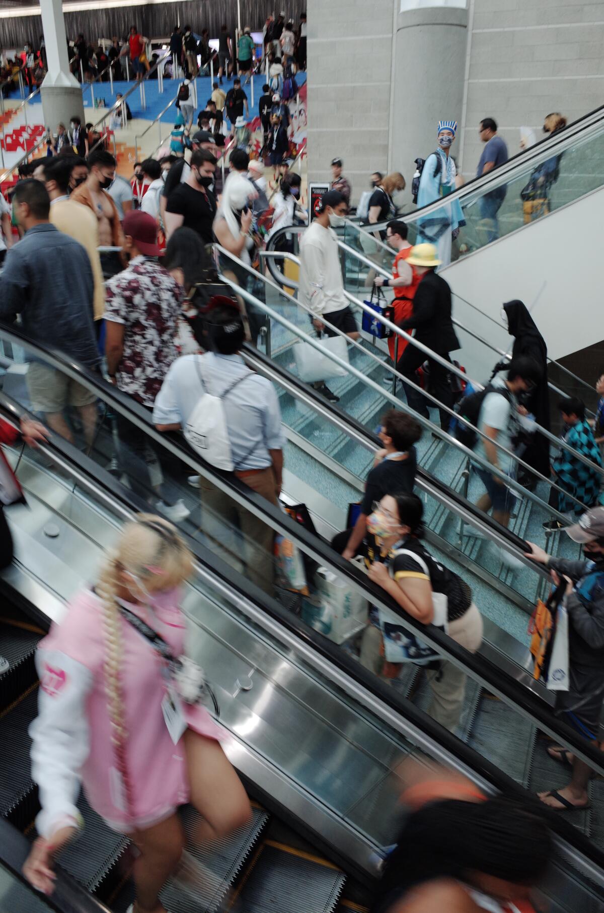 People on escalators, some wearing costumes