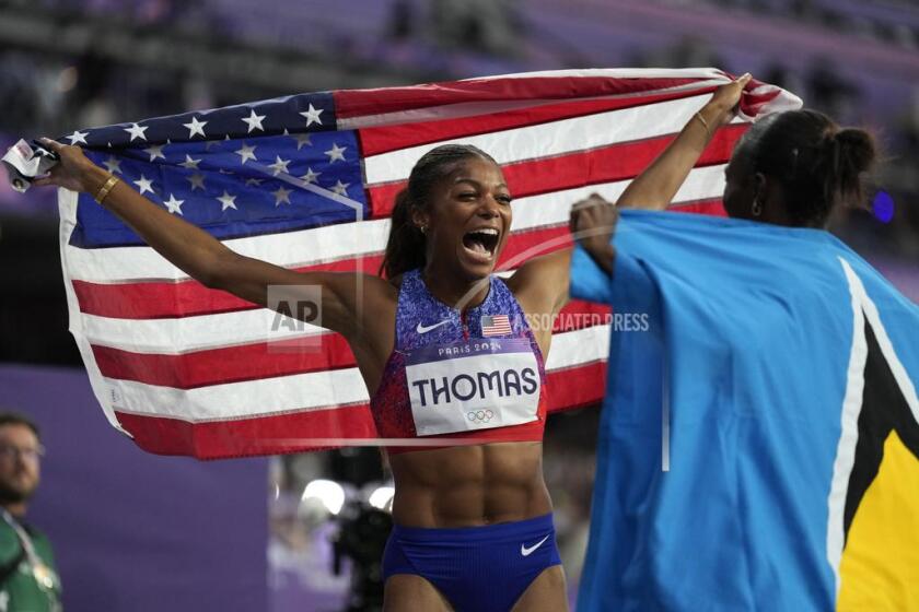 La estadounidense Gabby Thomas celebra su medalla de oro de los 200 metros con Julien Alfred de Santa Lucía en el atletismo de los Juegos Olímpicos de París, el martes 6 de agosto de 2024, en Saint-Denis, Francia. (AP Foto/Ashley Landis)