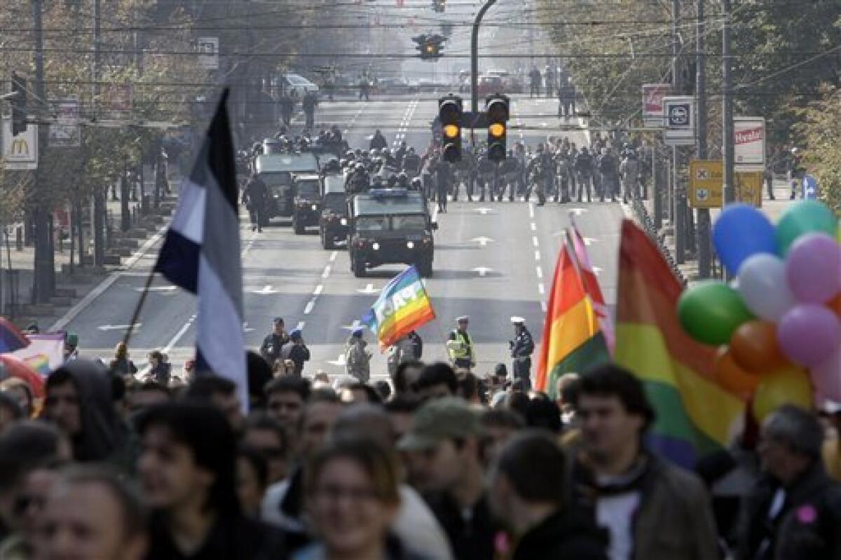Serbian riot gather as the gay parade goes moves along a street in Belgrade, Serbia, Sunday, Oct. 10, 2010. Riot police in Serbia clashed with some hundreds of far-right protesters who tried to disrupt the gay pride march in Belgrade on Sunday, with more than a dozen people reported injured, officials said.(AP Photo/Darko Vojinovic)
