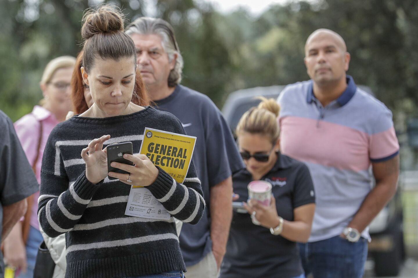 Aimee Kungl goes over her choices while waiting in line to vote at Orange County Fire Station No. 32 in Yorba Linda.