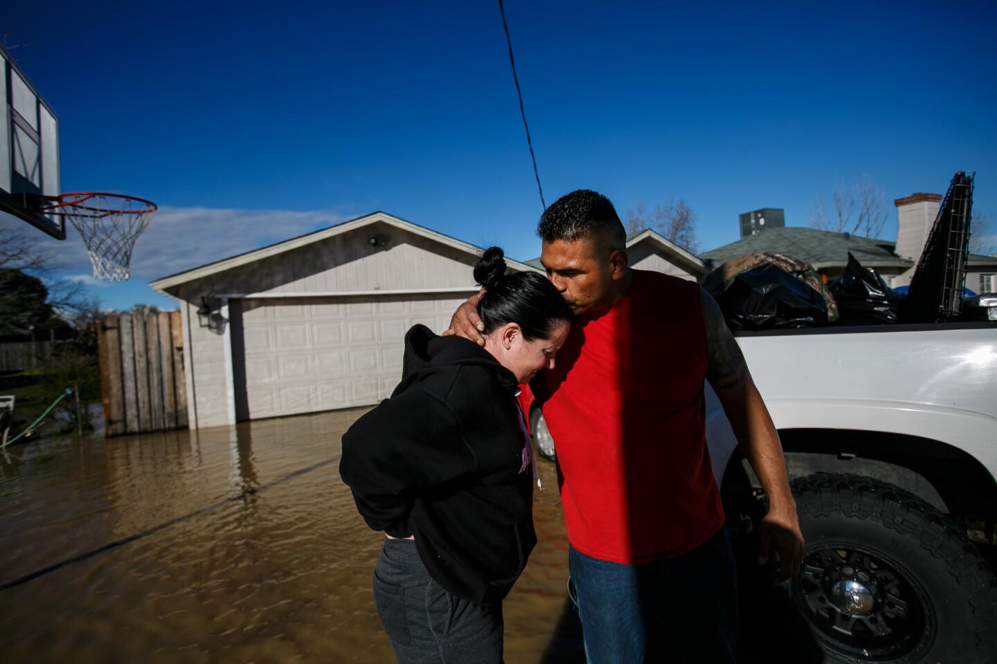 Juan Alvarez reassures his girlfriend, Sarah Hendrix, after helping her move out of her flooded home in Maxwell.