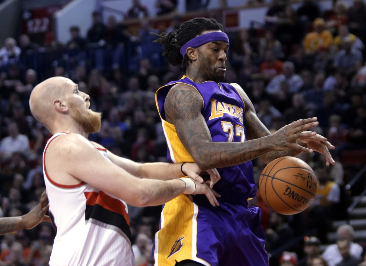 Lakers center Jordan Hill tries to corral a rebound in front of Trail Blazers center Chris Kaman in the first half Monday night in Portland.
