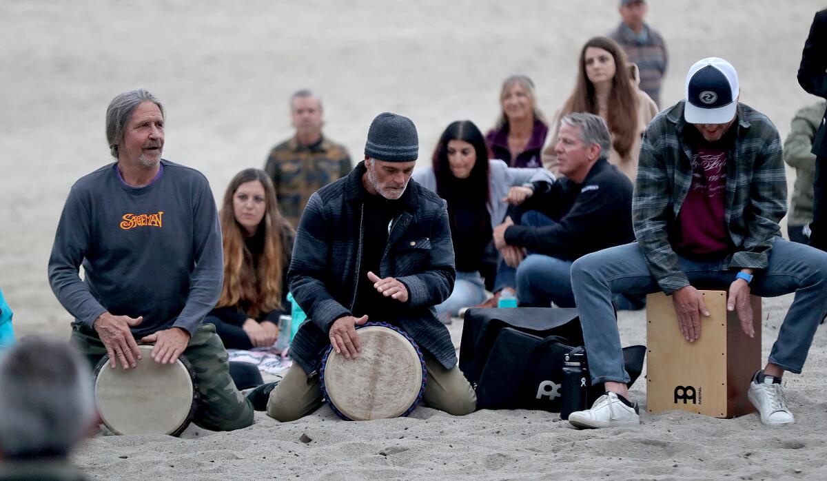 Fans and residents start the drum circle remembrance at Aliso Beach in honor of popular Foo Fighters drummer Taylor Hawkins.