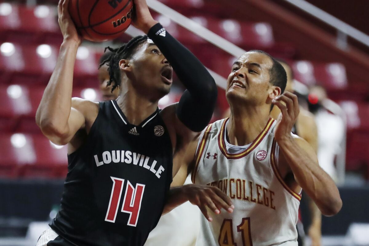 Louisville's Dre Davis (14) shoots against Boston College's Steffon Mitchell (41) during the first half of an NCAA college basketball game, Saturday, Jan. 2, 2021, in Boston. (AP Photo/Michael Dwyer)