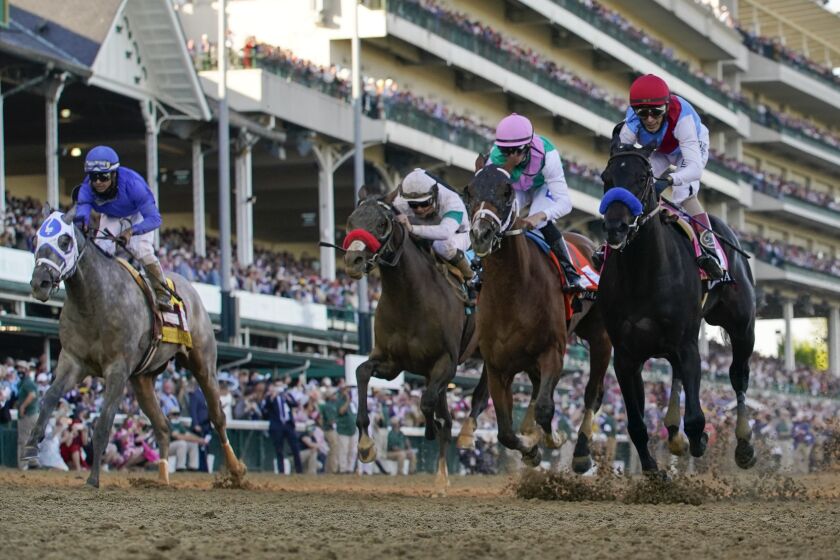John Velazquez riding Medina Spirit, right, leads Florent Geroux on Mandaloun, Flavien Prat riding Hot Rod Charlie and Luis Saez on Essential Quality to win the 147th running of the Kentucky Derby at Churchill Downs, Saturday, May 1, 2021, in Louisville, Ky. (AP Photo/Jeff Roberson)