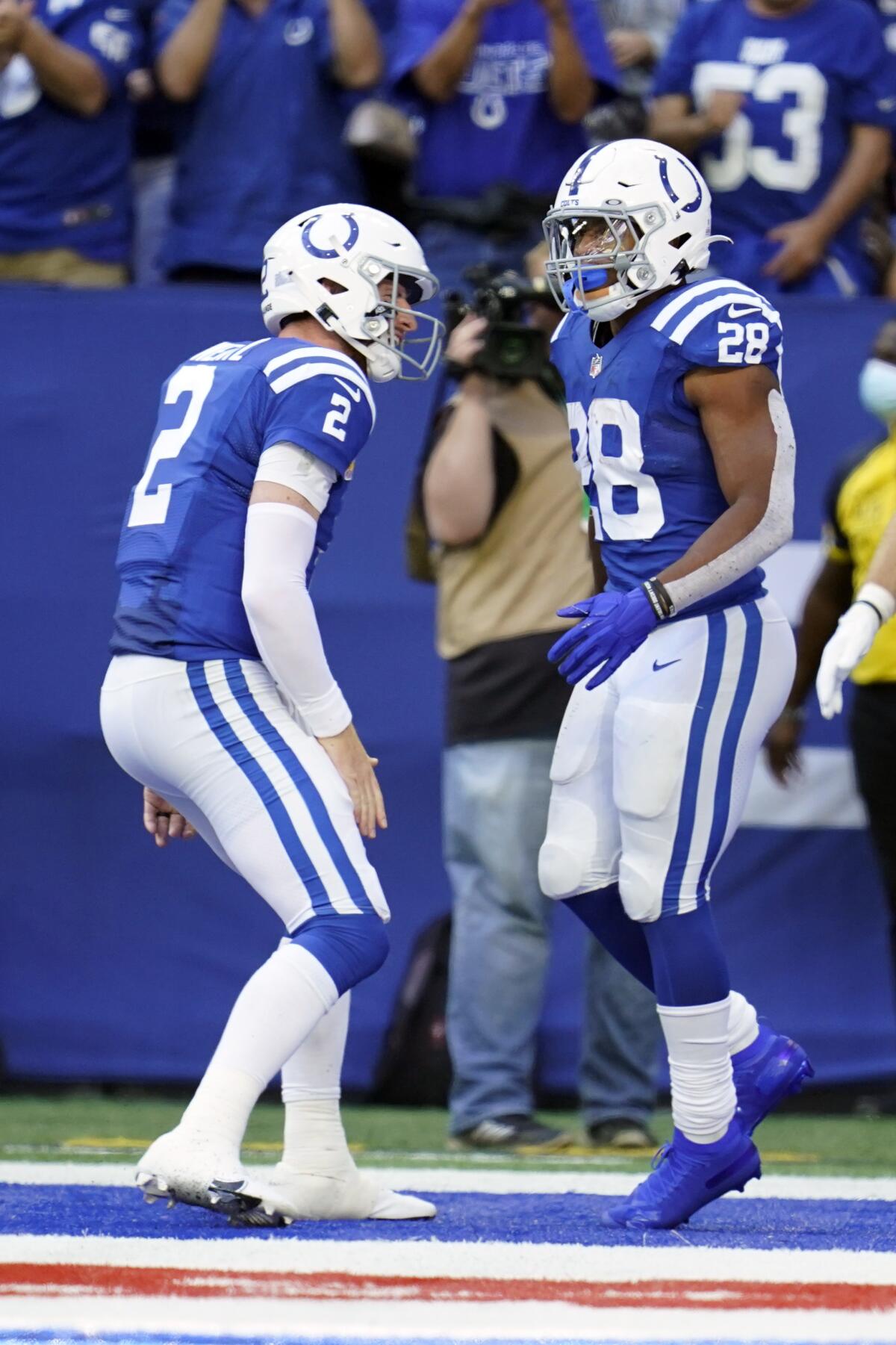 Indianapolis Colts' Jonathan Taylor (28) celebrates a rushing touchdown with quarterback Carson Wentz (2) during the second half of an NFL football game against the Houston Texans, Sunday, Oct. 17, 2021, in Indianapolis. (AP Photo/Michael Conroy)