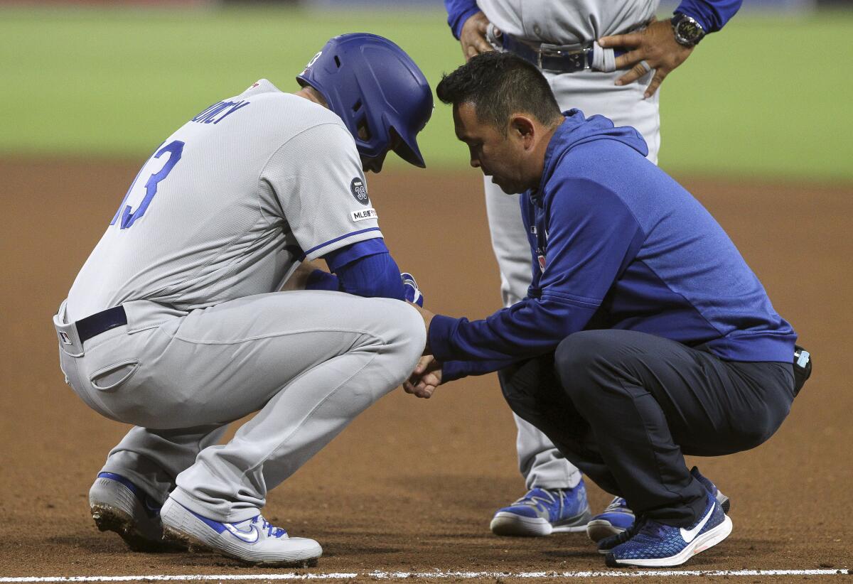 The Dodgers' Max Muncy is looked at after he was hit by a pitch against the Padres on Aug. 28. 