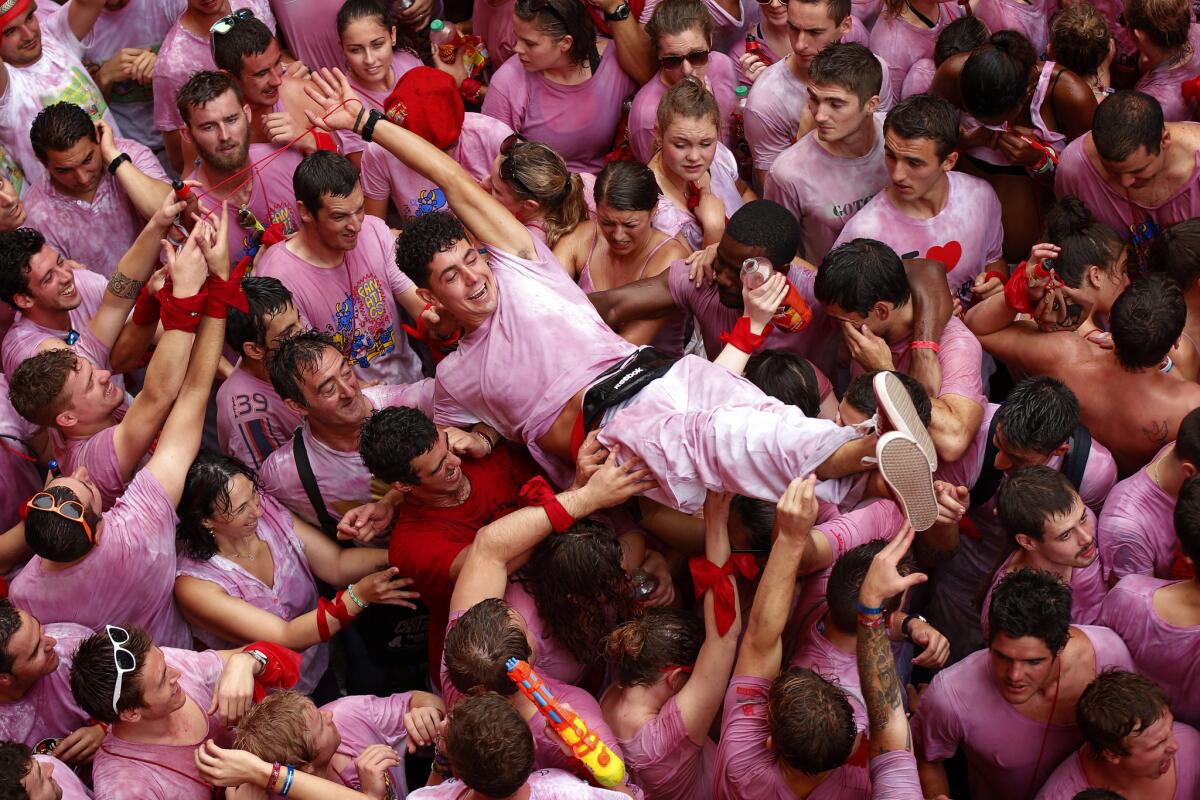 A reveler is lifted above the crowd during the launch of the 'Chupinazo' rocket, to celebrate the official opening of the 2014 San Fermin fiestas, in Pamplona, Spain.