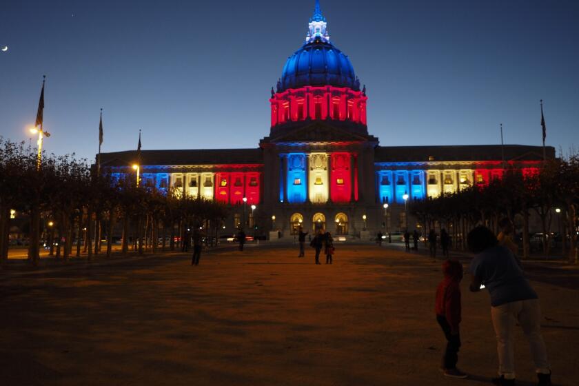 San Francisco City Hall is illuminated with the French national colors as a sign of solidarity with the victims of the deadly Paris attacks.