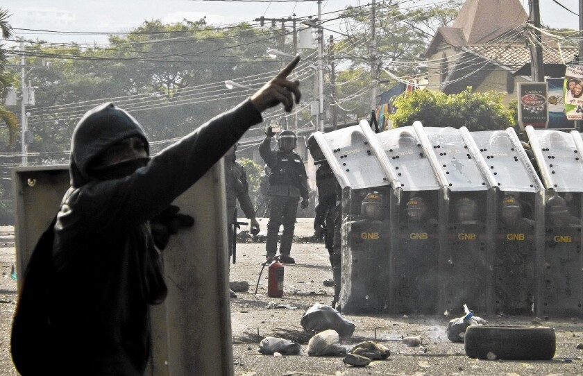 A protester faces national guard troops in San Cristobal, Venezuela, last week.