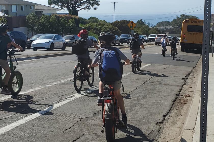 Young bicyclists leaving Muirlands Middle School ride down Nautilus Street in La Jolla.