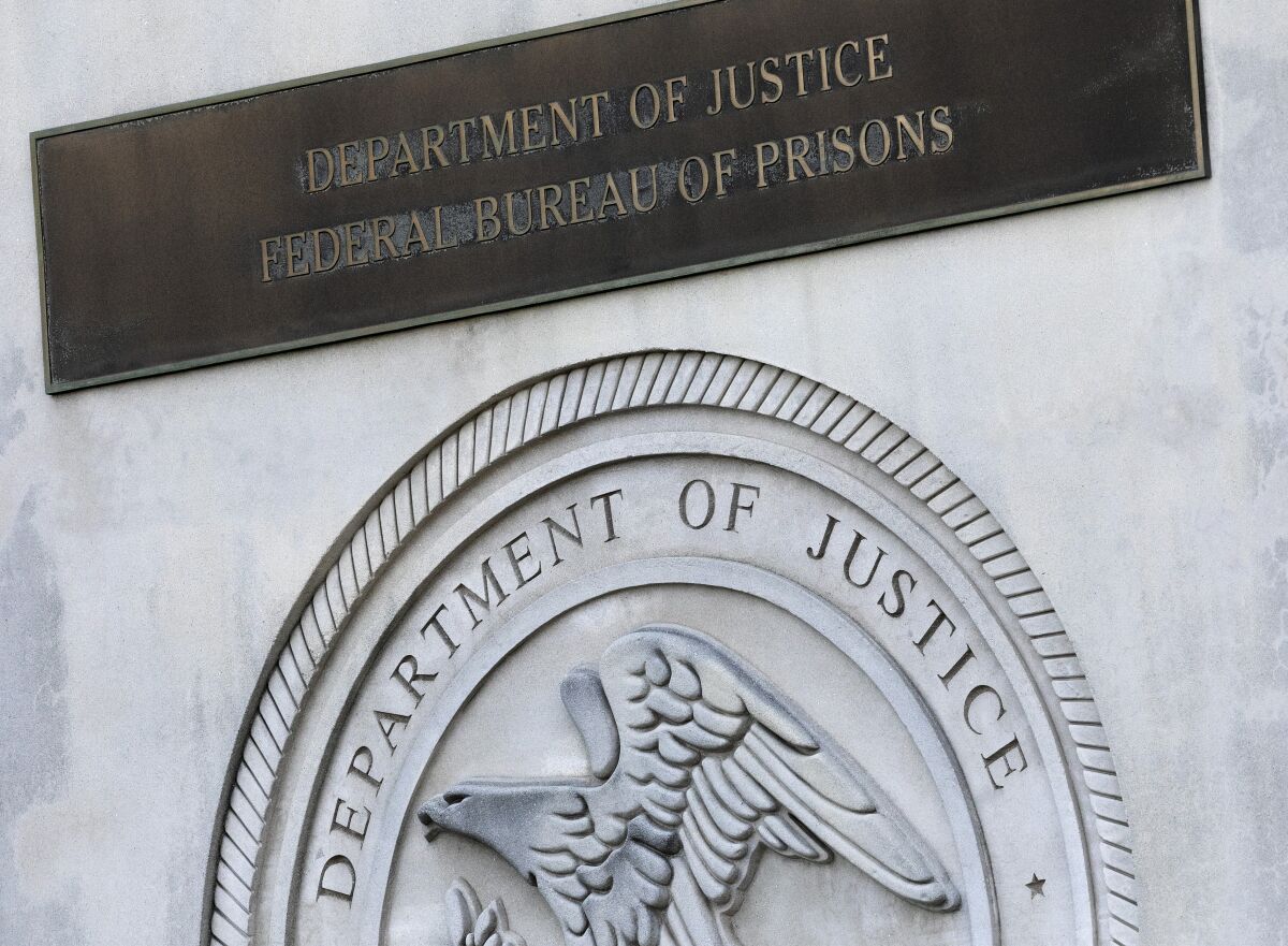 A sign for the Department of Justice Federal Bureau of Prisons is displayed at the Metropolitan Detention Center, Monday, July 6, 2020, in the Brooklyn borough of New York. Jeffrey Epstein's longtime confidante Ghislaine Maxwell has been transferred to New York to face charges she recruited women and girls for him to sexually abuse. The Bureau of Prisons confirmed that Maxwell was transferred Monday and is currently being held at the MDC. (AP Photo/Mark Lennihan)