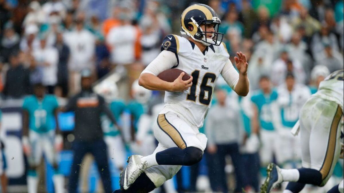Rams quarterback Jared Goff runs against the Miami Dolphins at the Coliseum last season in gold-striped pants. The Rams' uniforms will lose that gold stripe for the upcoming season.