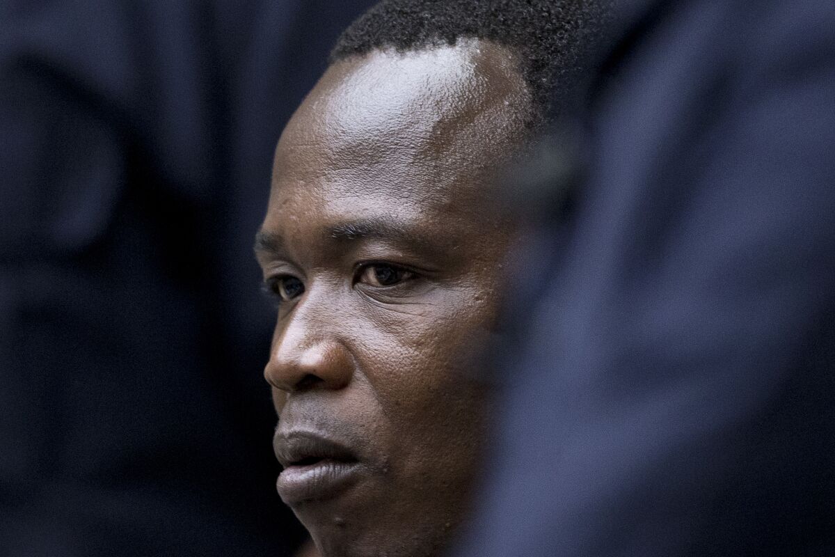 FILE - In this Tuesday, Dec. 6, 2016 file photo, Dominic Ongwen, a senior commander in the Lord's Resistance Army, whose fugitive leader Kony is one of the world's most-wanted war crimes suspects, is flanked by two security guards as he sits in the court room of the International Court in The Hague, Netherlands. Ongwen was convicted in February, 2021 of a total of 61 war crimes and crimes against humanity including murder, rape, forced marriage, forced pregnancy and using child soldiers. His lawyers have said they will appeal the conviction. (AP Photo/Peter Dejong, Pool, File)