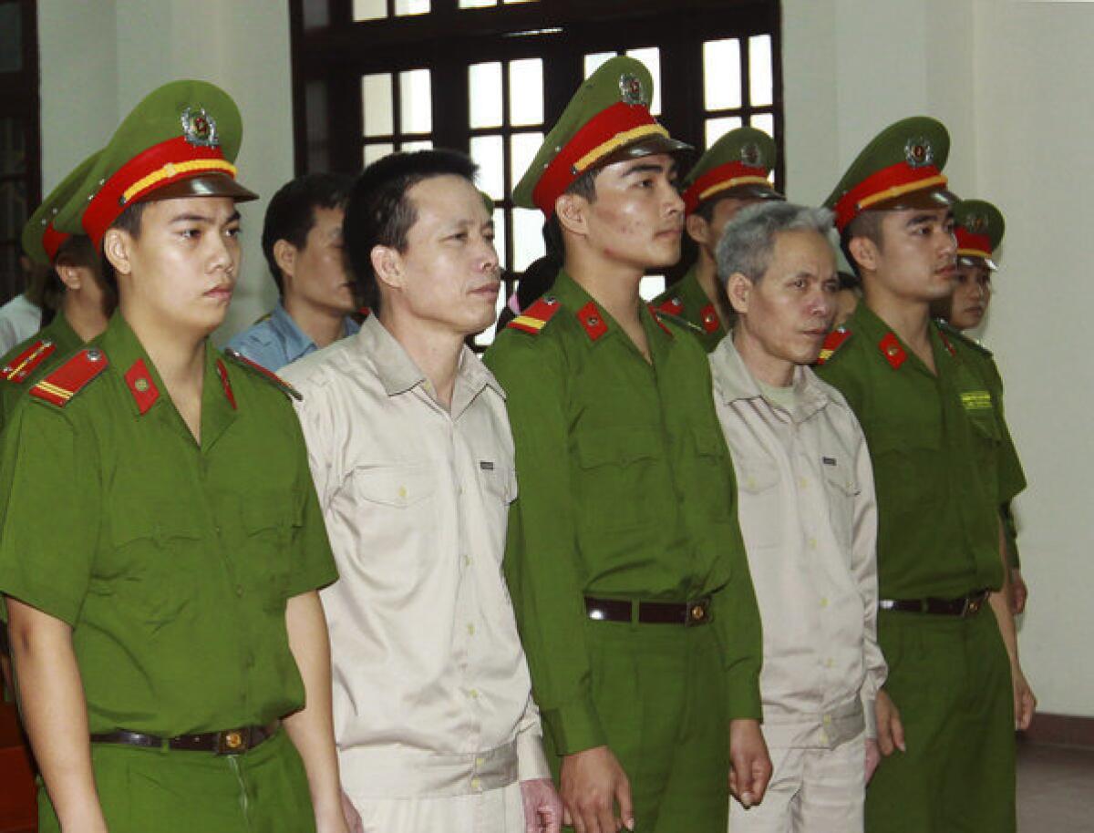 Doan Van Vuon, second from left, and his brother Doan Van Sinh, fourth from left, stand trial in Haiphong, northern Vietnam.
