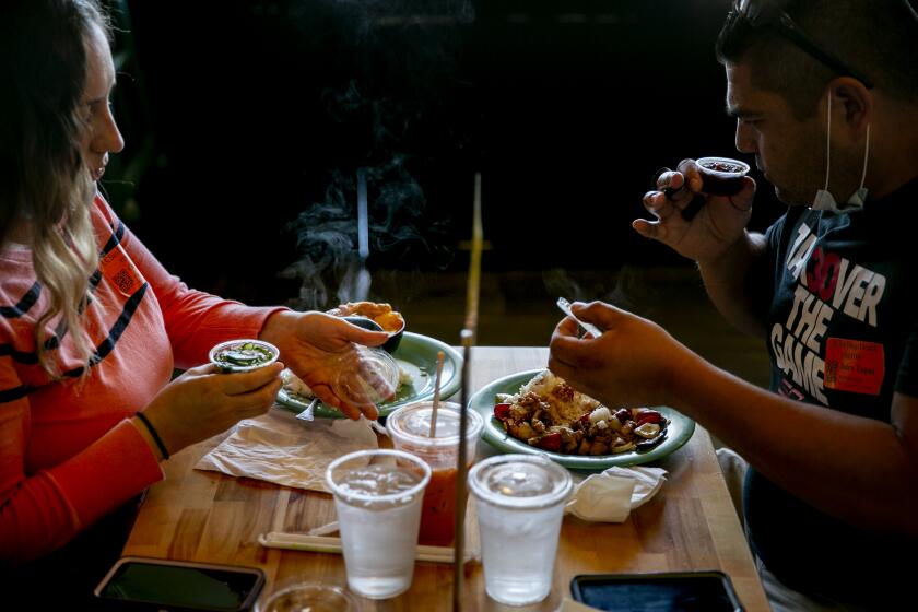 Carla Tapia and Jairo Tapia of Chula Vista enjoy a meal as diners eat at Saffron Thai on May 21, 2020 in San Diego, California. Restaurants began reopening for dine-in patrons on Thursday as the state and county began easing restrictions imposed during the coronavirus pandemic.