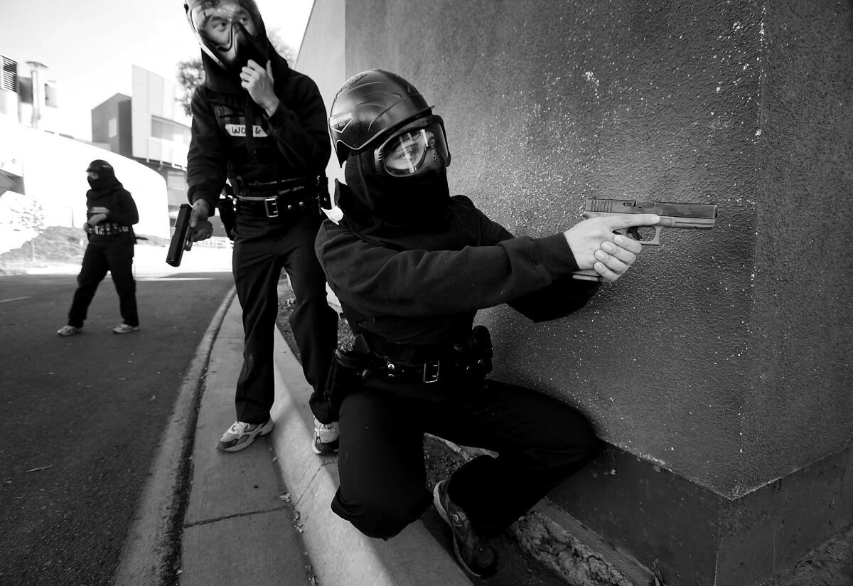 Police recruits use paintball guns to practice shooting scenarios.