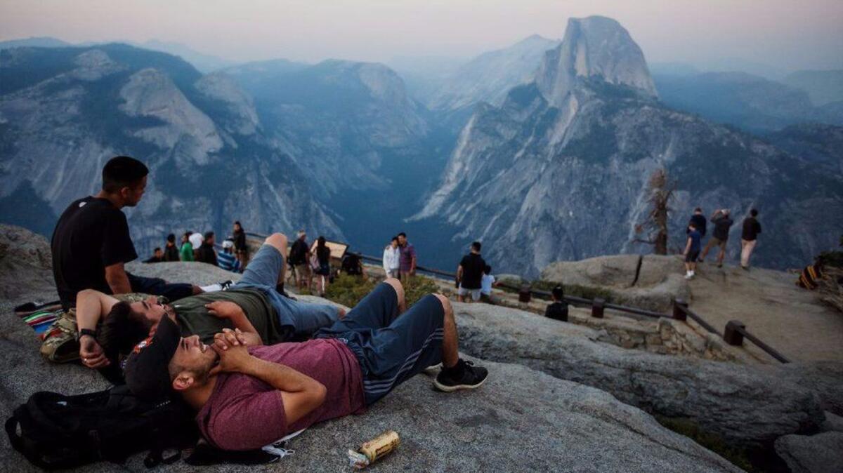 Yosemite National Park visitors gather at a viewing spot for Half Dome, shrouded by smoke from nearby fires, in July.