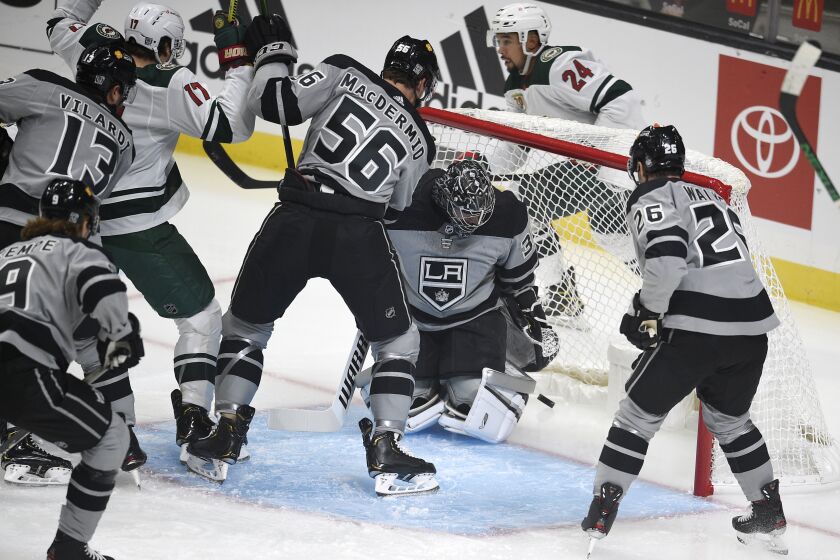 Los Angeles Kings goalie Jonathan Quick, center, looks down after allowing a goal by Minnesota Wild.