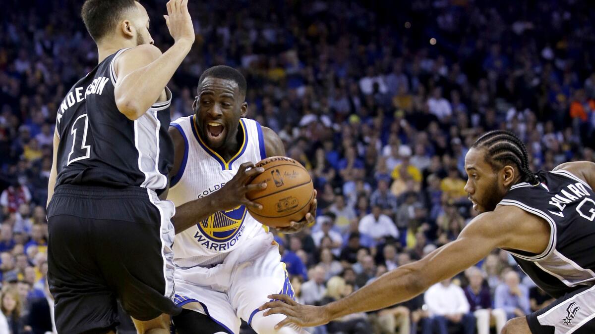Warriors forward Draymond Green drives between Spurs forwards Kyle Anderson (1) and Kawhi Leonard during the first half Thursday night.