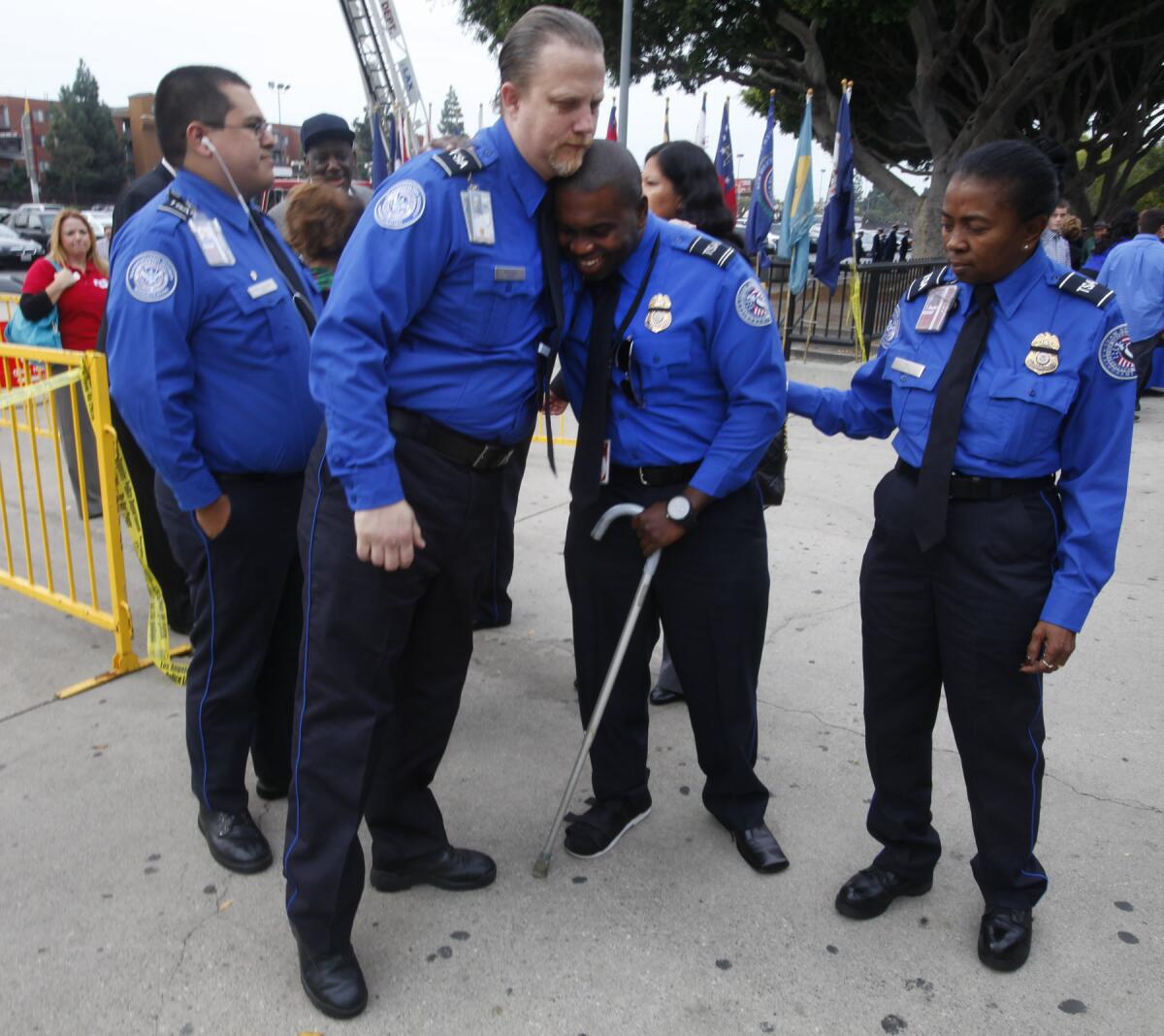 Wounded TSA Officer Tony Grigsby, center, is greeted by fellow officers as he arrives for the public memorial service for slain Transportation Security Administration agent Gerardo Hernandez at the Los Angeles Sports Arena on Tuesday.
