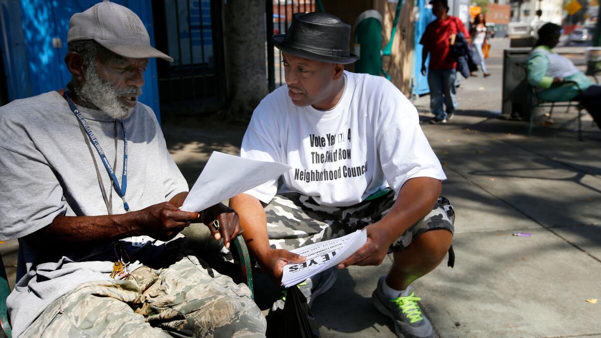 General Jeff Page, right, speaks with Terry Prescod at Gladys Park on skid row before the April 5 vote over the proposed neighborhood council.