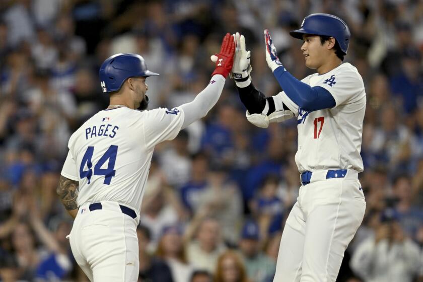 El cubano Andy Pagés de los Dodgers de Los Ángeles felicitado por Shohei Ohtani tras su jonrón de dos carreras en la tercera entrada ante los Piratas de Pittsburgh el viernes 9 de agosto del 2024. (AP Foto/John McCoy)