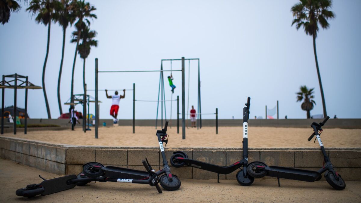 Westside vandals are waging a guerrilla war against pay-per-mile scooters. These Bird electric scooters were left on the Venice Beach boardwalk.