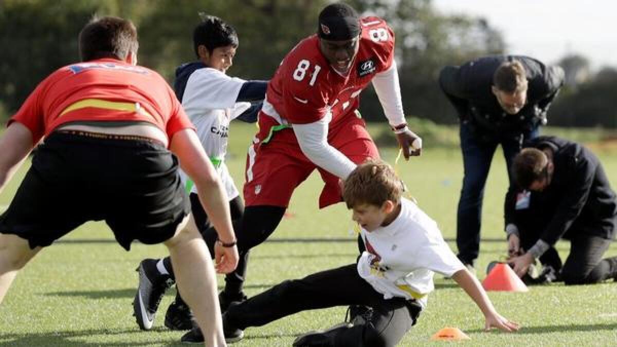 Arizona Cardinals practice squad tight end Anthony Denham takes part in an NFL flag football event with local schoolchildren at the London Irish rugby team training ground.