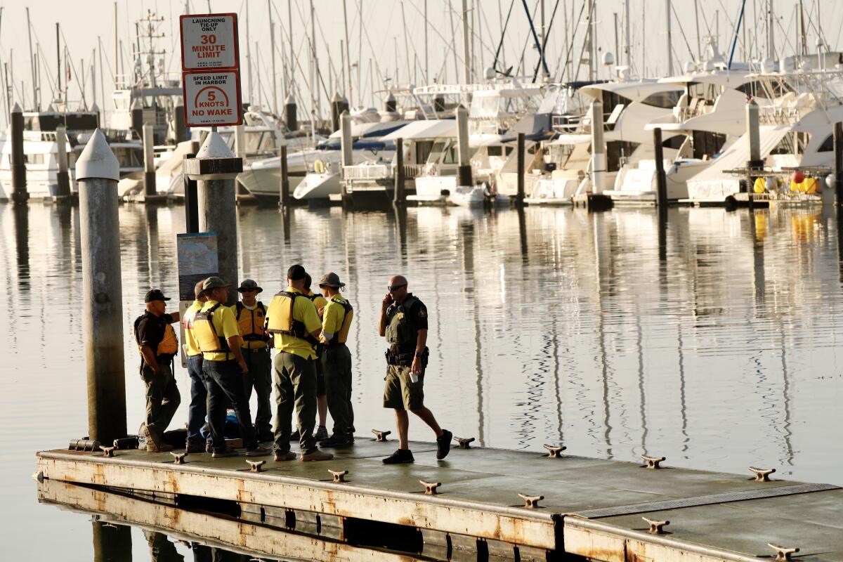 Law enforcement officials at Santa Barbara Harbor wait for a boat to take them to the scene of the deadly boat fire off Santa Cruz Island.