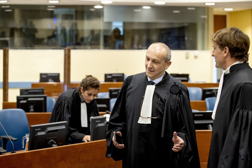 FILE - Felicien Kabuga's defense lawyer Emmanuel Altit, left, speaks with prosecutor Rupert Elderkin in court at the UN International Residual Mechanism for Criminal Tribunals (IRMCT) in The Hague, Thursday, Sept. 29 2022. United Nations judges have on Wednesday, June 7, 2023 declared Kabuga, an elderly Rwandan genocide suspect, unfit to continue to stand trial because he has dementia and will establish a procedure to continue to hear evidence without the possibility of convicting him. (Koen van Weel/Pool Photo via AP, file)