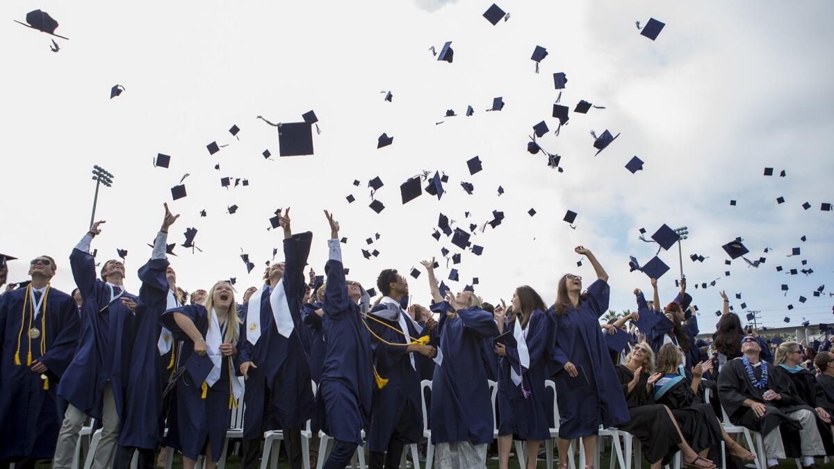 Graduates toss their caps during the Newport Harbor High School commencement at Davidson Field on June 22, 2017.