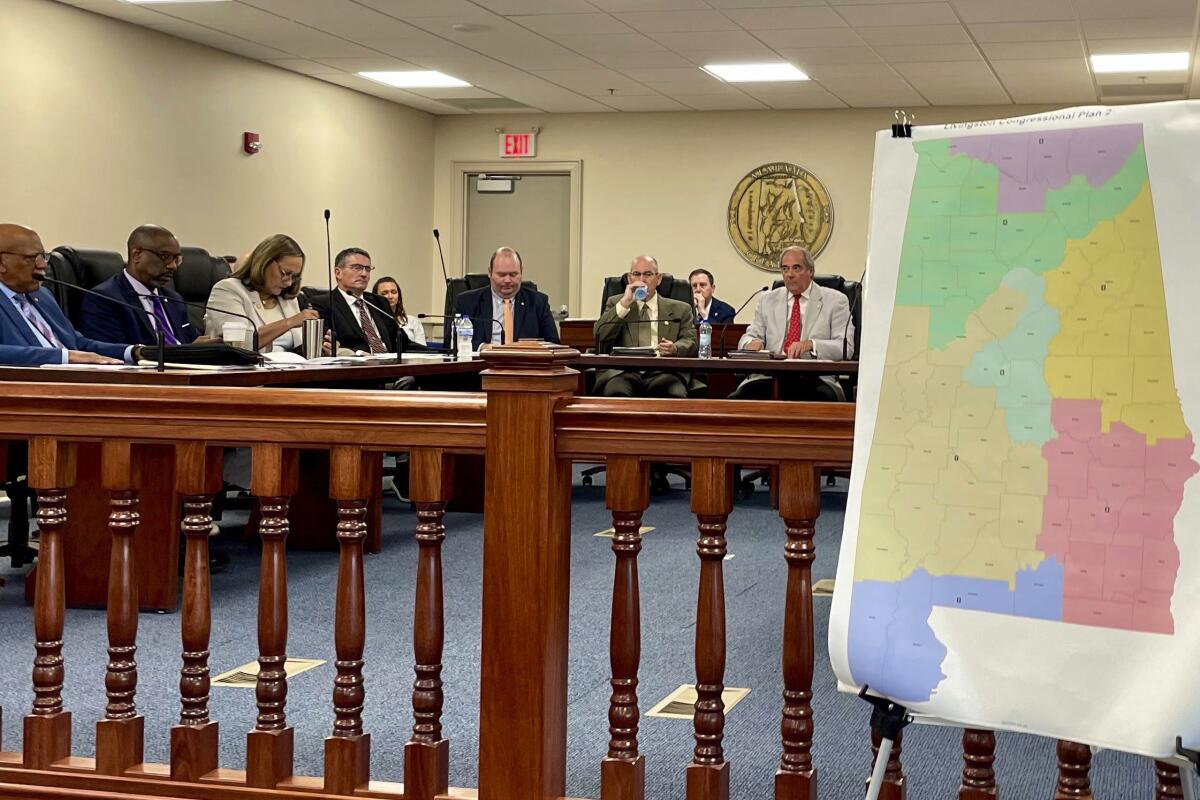 An Alabama Senate committee sits near a multicolored map.