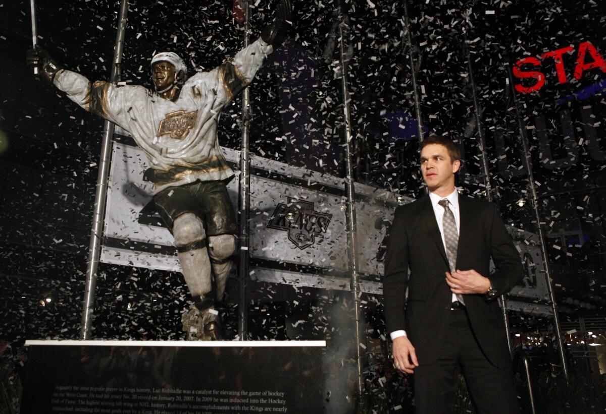 Kings great Luc Robitaille steps in front of his newly unveiled bronze statue outside Staples Center at Star Plaza during a ceremony on Saturday night.