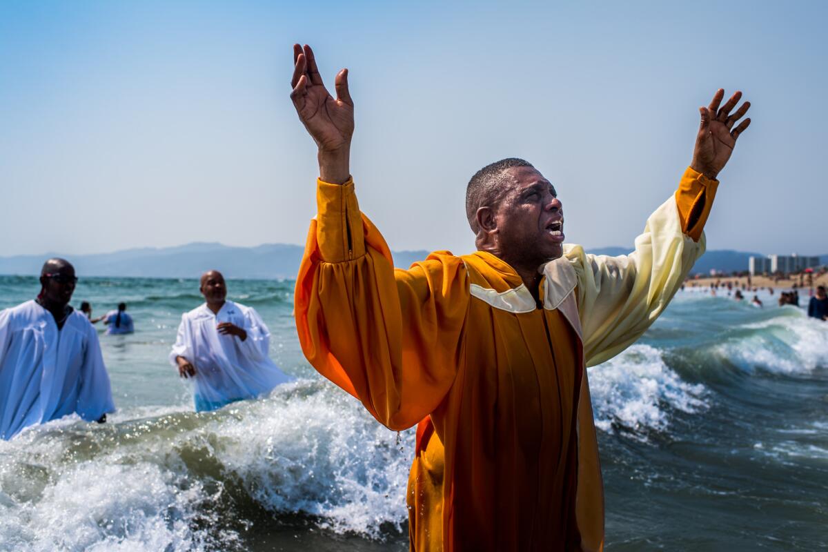 Bishop John Moore, left, and Bishop Willie Pickens baptize a man, who did want to be identified by name, during the Disciples on the Move rally.