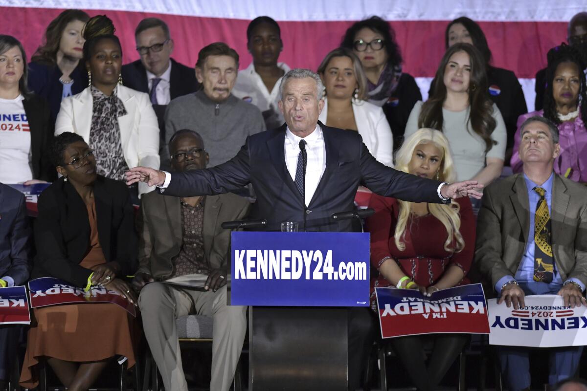 Robert F. Kennedy Jr. announces his presidential candidacy with several people sitting behind him.