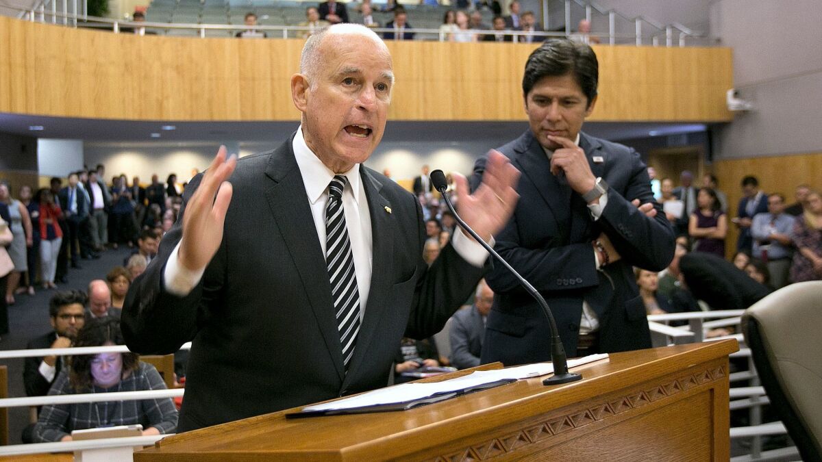 Gov. Jerry Brown, flanked by Senate President Pro Tem Kevin de León, urges members of the Environmental Quality Committee to approve a pair of bills to extend cap and trade.