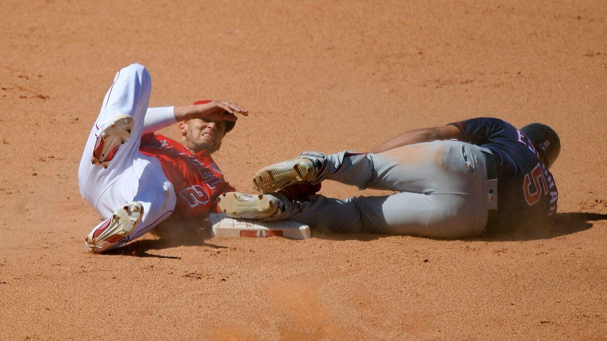 Minnesota Twins' Eduardo Escobar, right, lies on the ground after colliding with Angels shortstop Andrelton Simmons while stealing second base in the ninth inning.